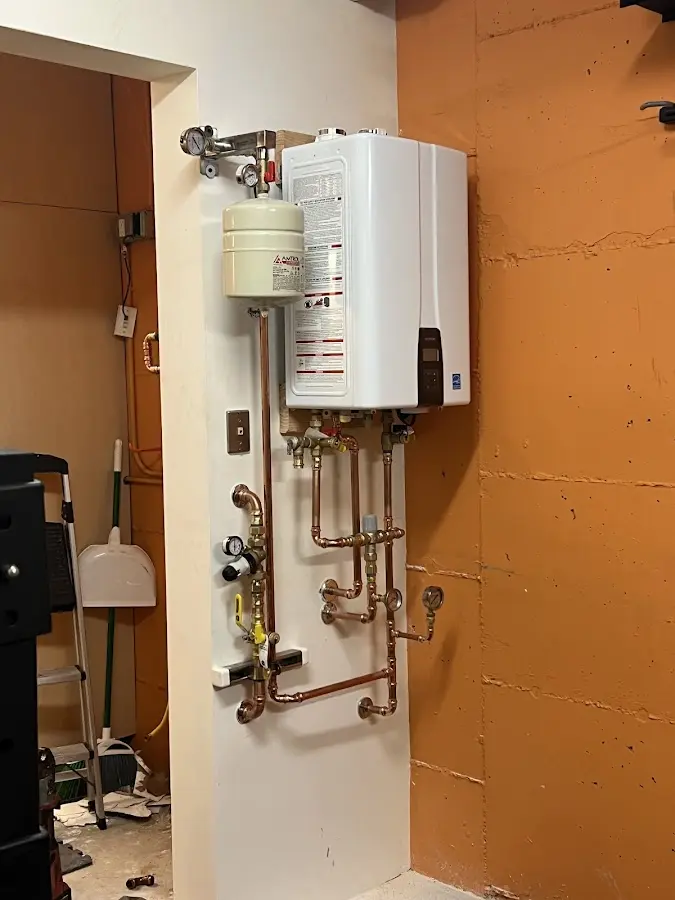 Plumbing technician inspecting water heater connections in Champaign
